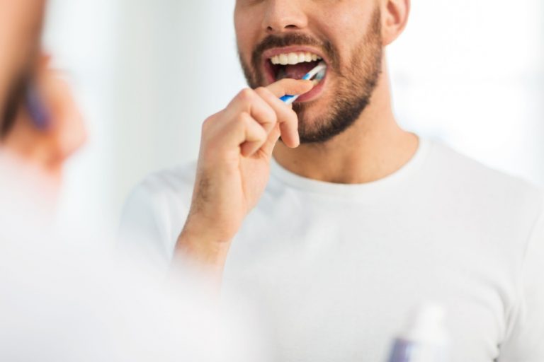 man brushing his teeth